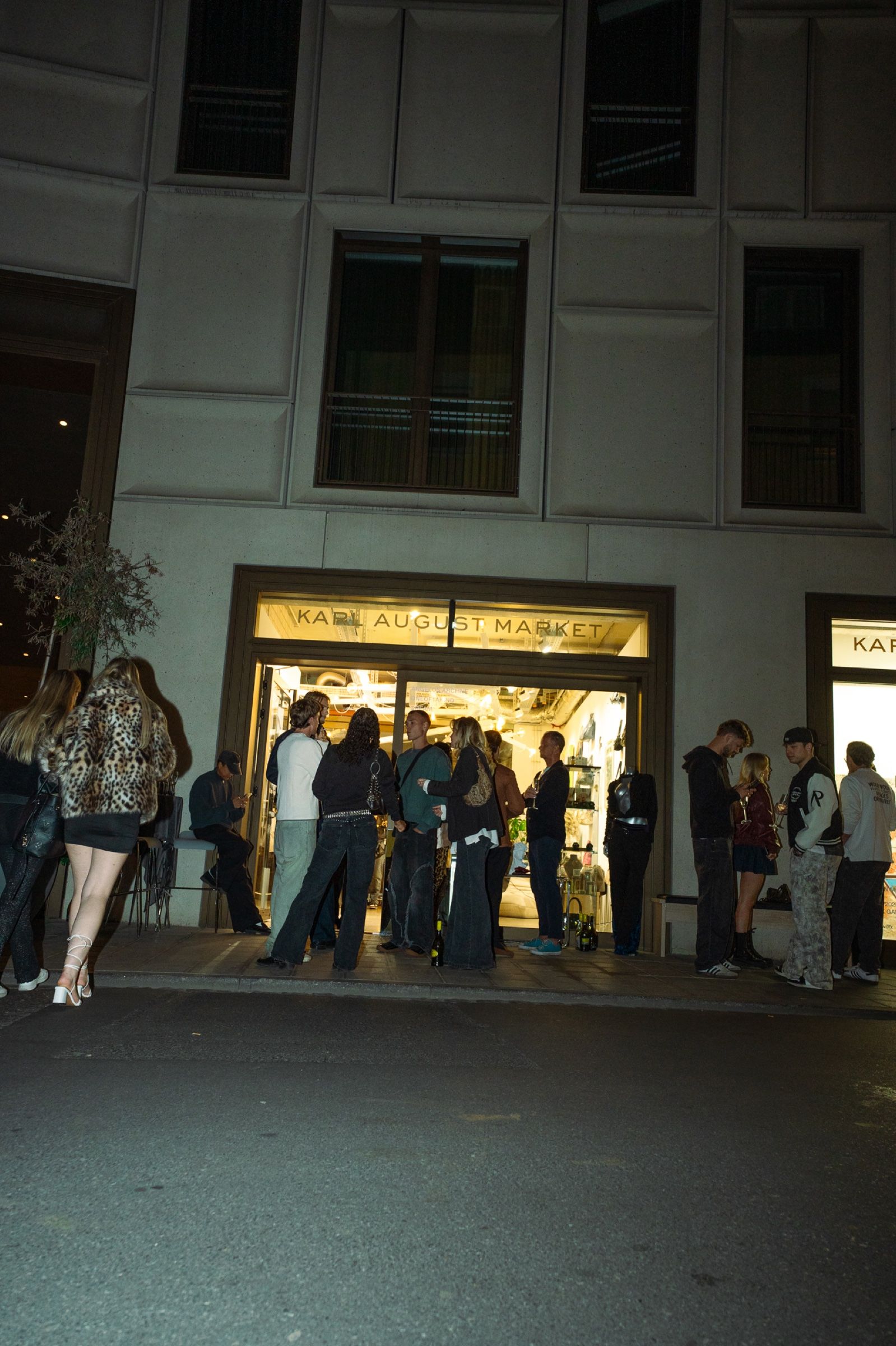 Guests in front of the lit entrance of an Artable pop-up event at night