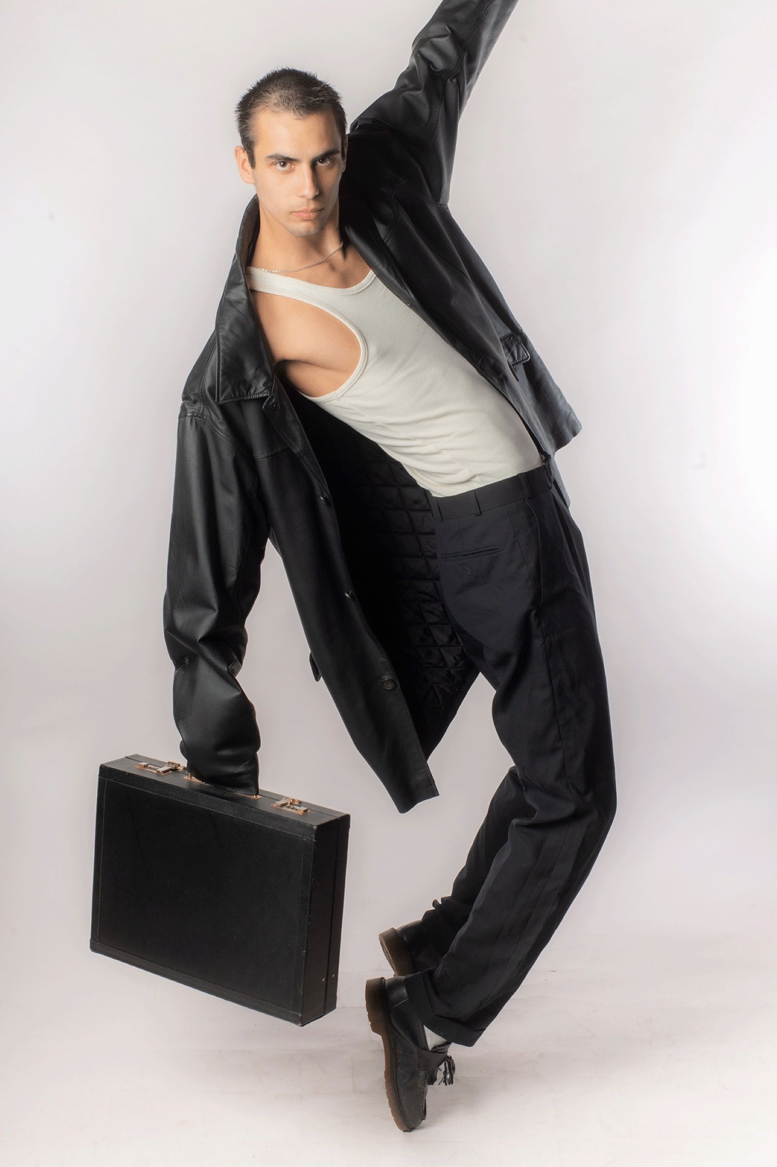 Modeaufnahme in Bewegung, Model mit Mantel und Aktenkoffer