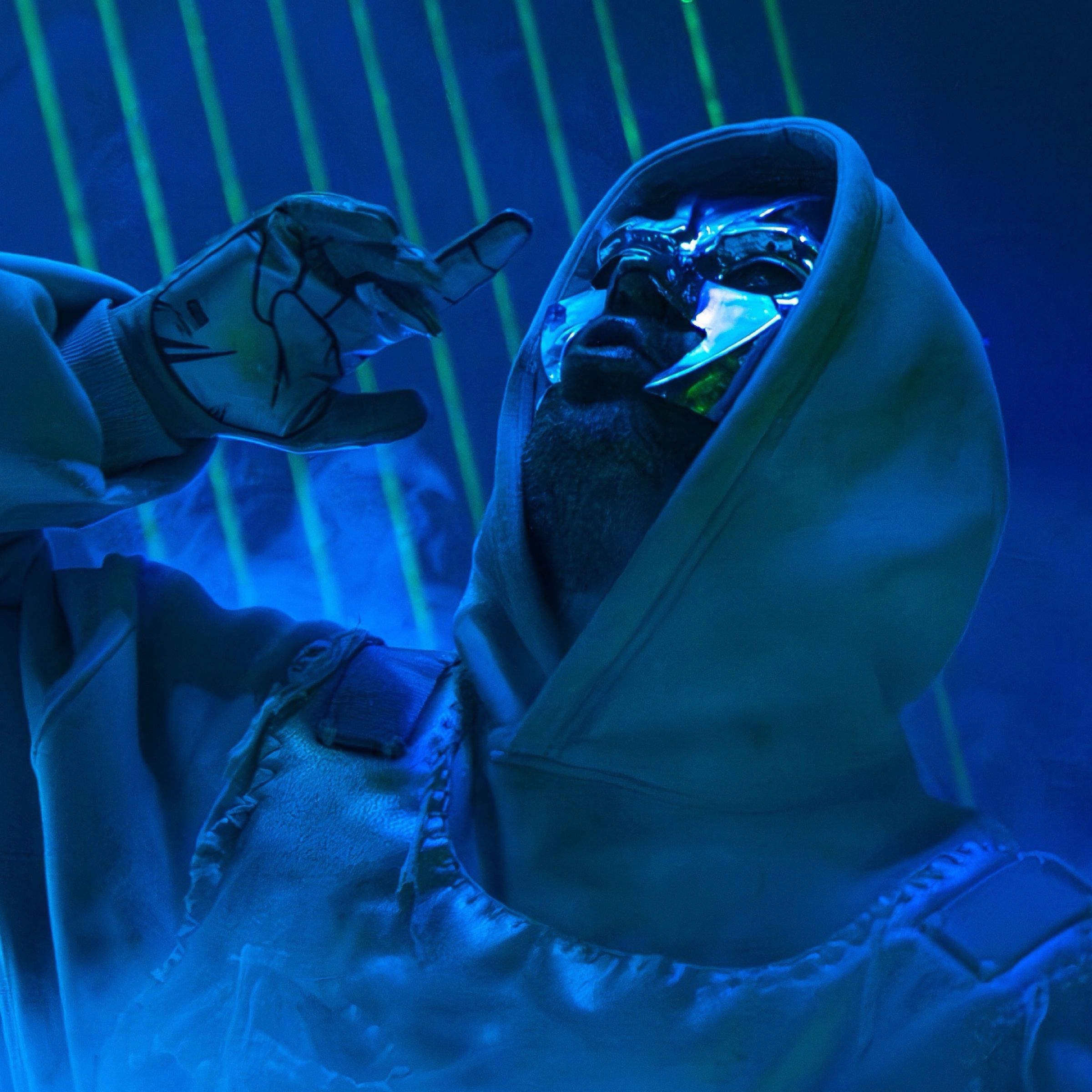 Rapper mit Kapuze und Kette in blauem Licht, Nahaufnahme