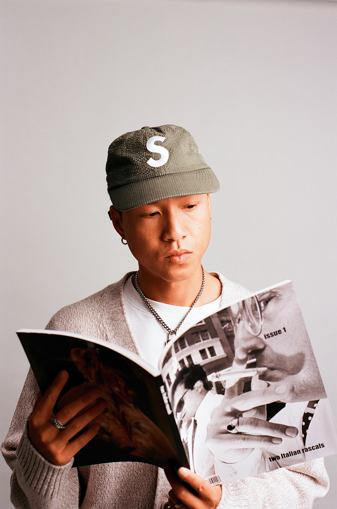 Portrait mit Cap, Magazin in den Händen